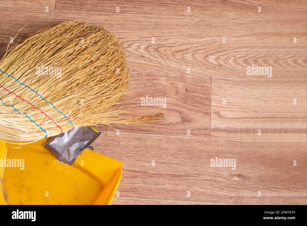 Broom and scoop removes garbage on wooden floor copy space Stock Photo