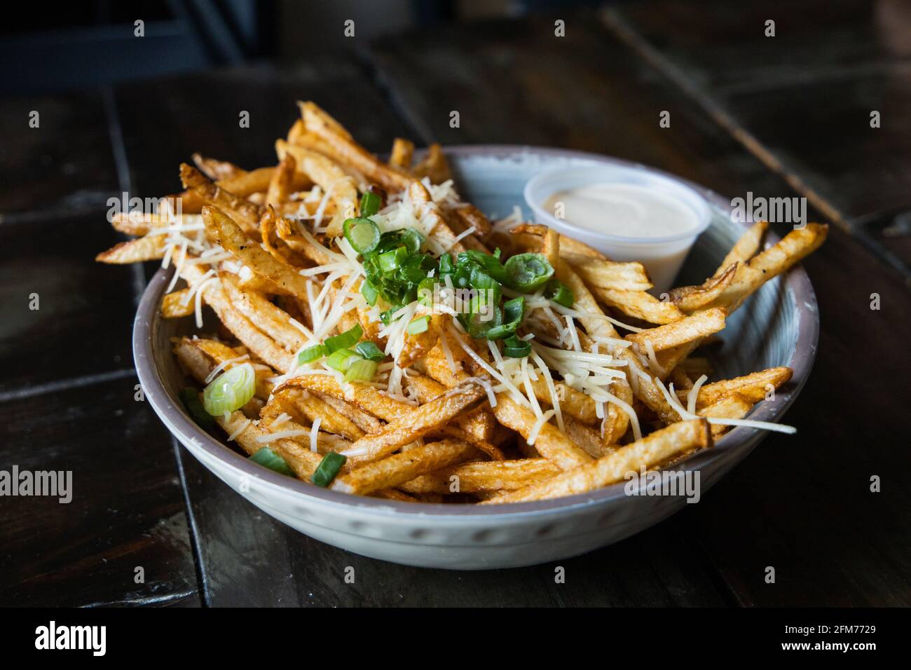 A large bowl of gourmet black truffle french fries in a bowl sprinkled