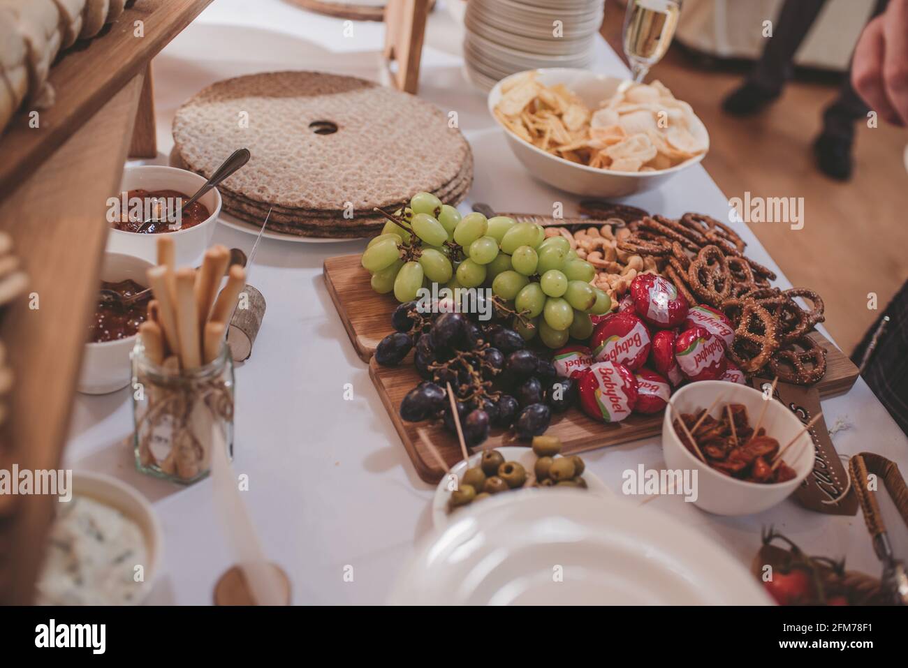 buffet board with grapes, cheese and breadsticks Stock Photo