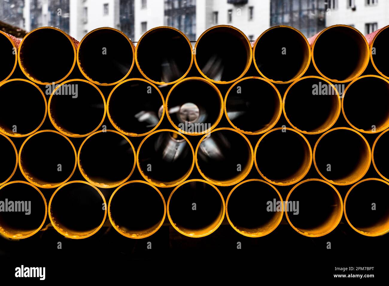 Pile of round industrial material polyethylene thermoplastic pipes on a construction site. Stock Photo