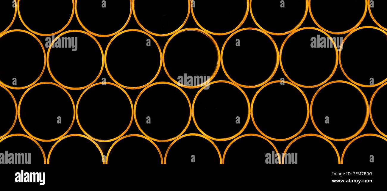 Pile of round industrial material polyethylene thermoplastic pipes on a construction site. Stock Photo