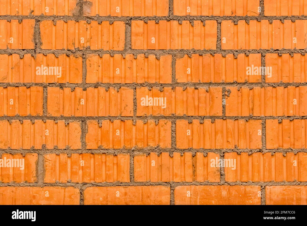 Masonry brown building brick, orange abstract wall texture with blocks construction background. Stock Photo