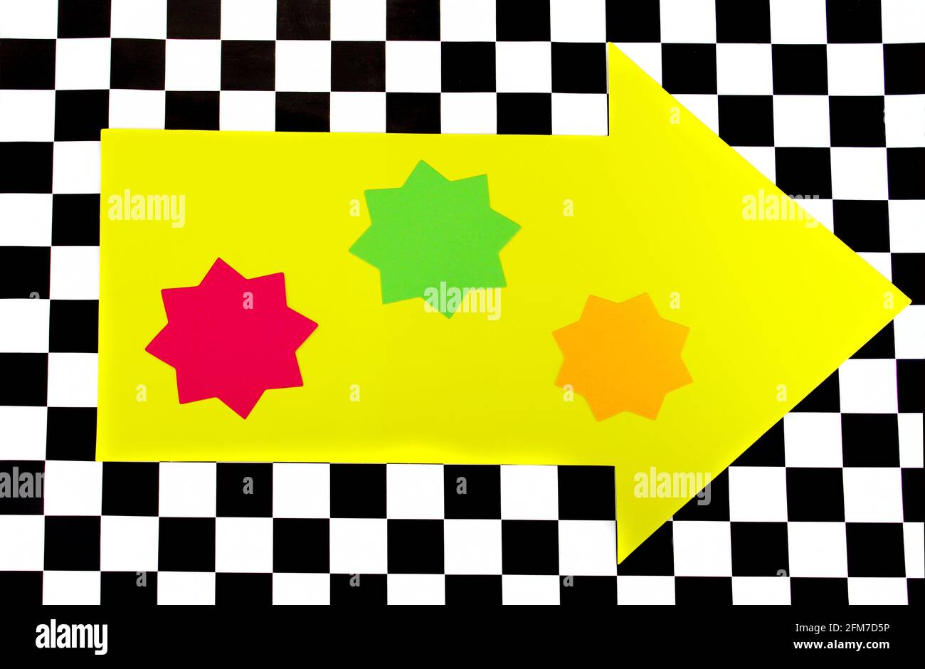 Photograph of Bright Neon Colored Shapes on Black and White Checkerboard pattern Stock Photo