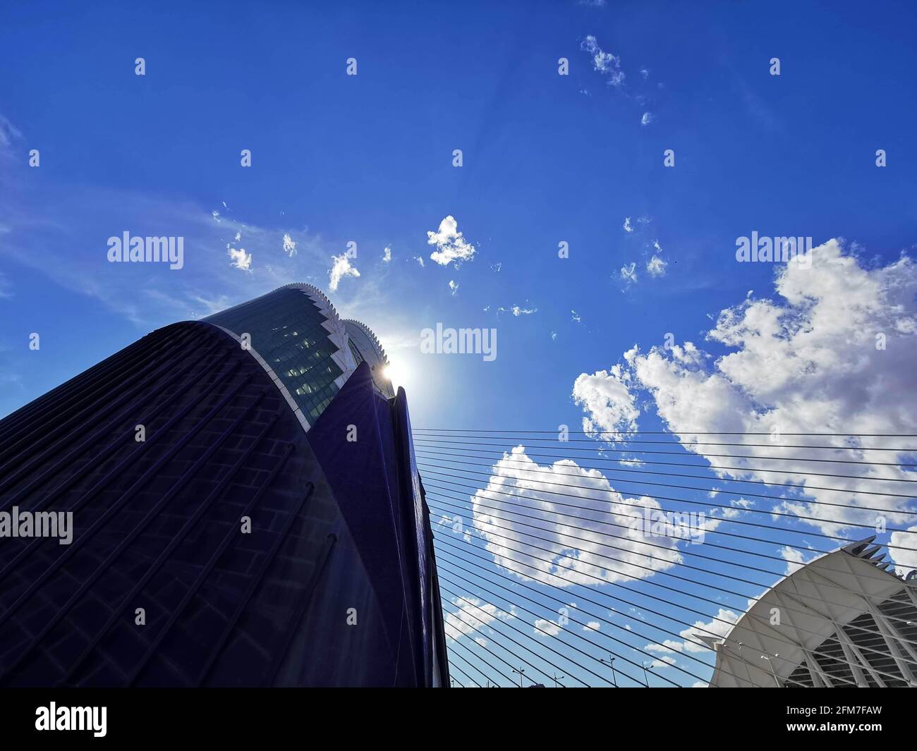 Low angle shot of a modern skyscraper under a beautiful blue cloudy sky ...