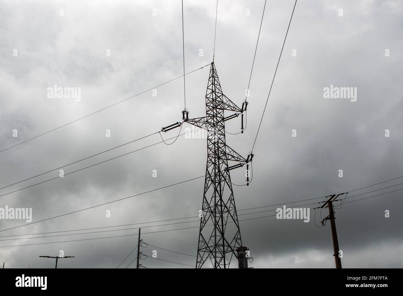 High voltage tower with stormy sky in the background Stock Photo - Alamy