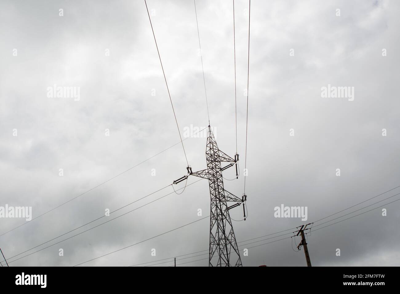 High voltage tower with stormy sky in the background Stock Photo - Alamy