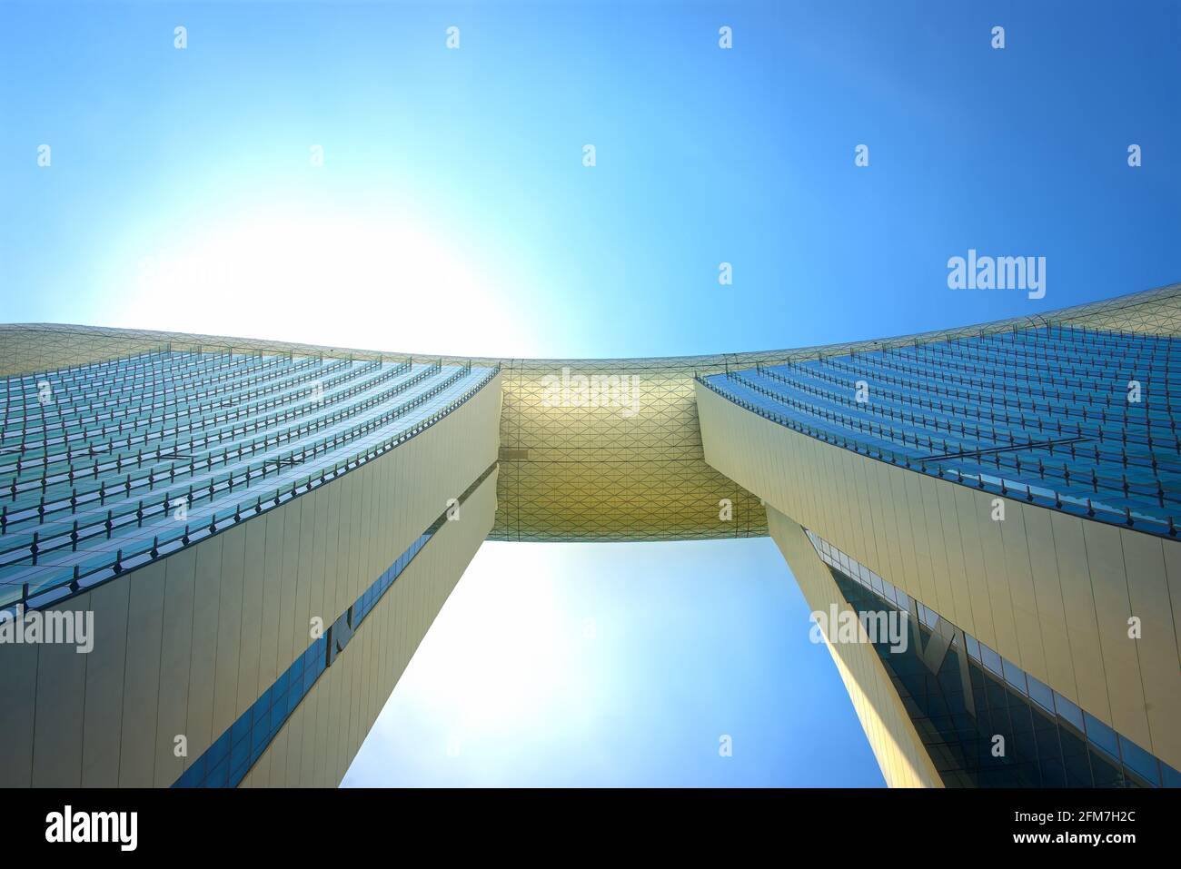 Perspective view of landmark Marina Bay Sands and skybridge against blue sky in Marina Bay, Singapore Stock Photo