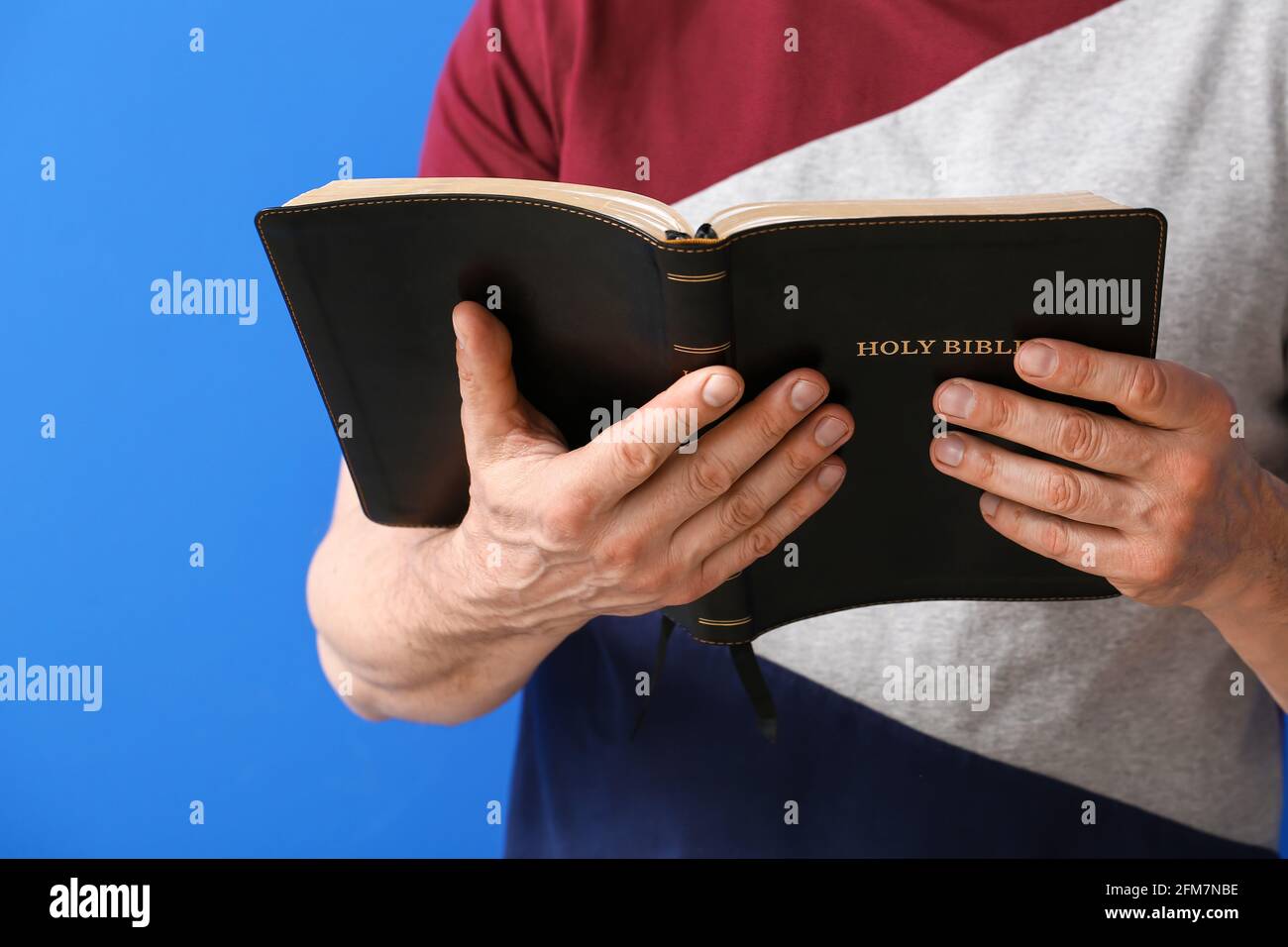 Man with Bible on color background, closeup Stock Photo