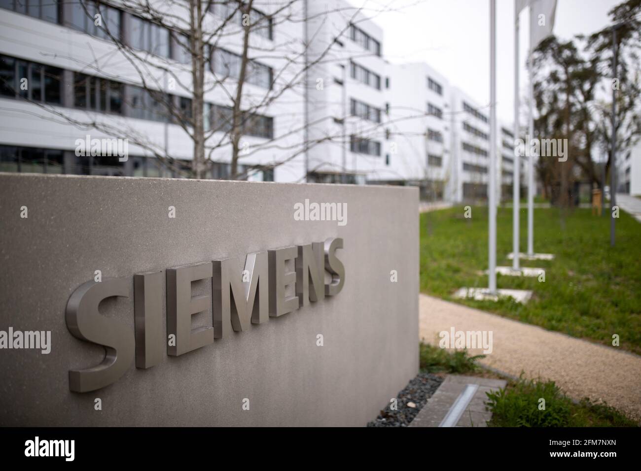 PRODUCTION - 30 April 2021, Bavaria, Erlangen: The lettering logo of the  German industrial corporation Siemens, stands on a stele at the entrance to  the Siemens Campus Erlangen. Office and administrative workplaces