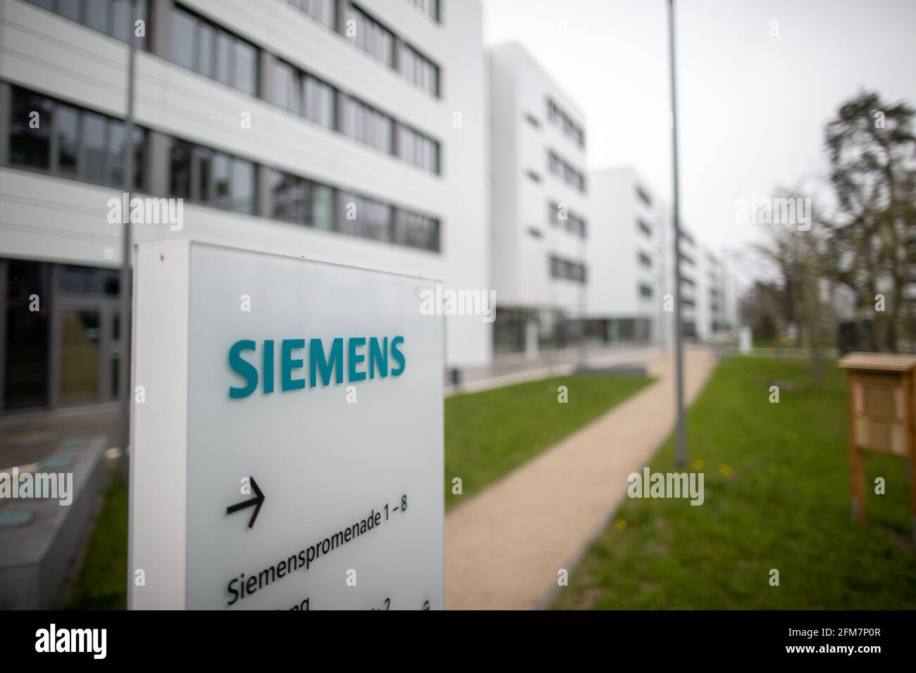 PRODUCTION - 30 April 2021, Bavaria, Erlangen: The lettering logo of the  German industrial corporation Siemens, stands on a stele on the Siemens  Campus Erlangen. Office and administrative workplaces as well as