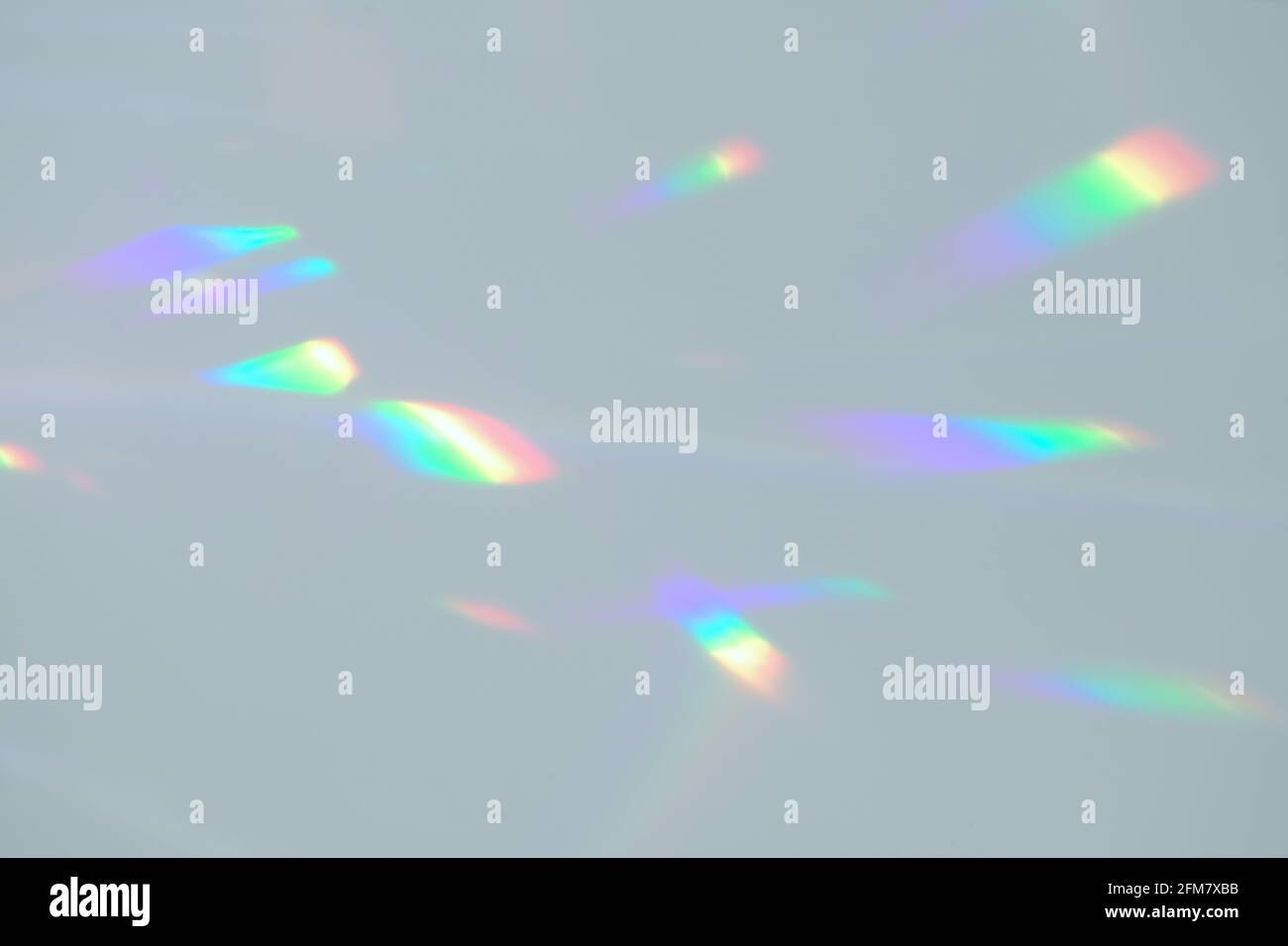 Blurred rainbow light refraction texture on white wall Stock Photo