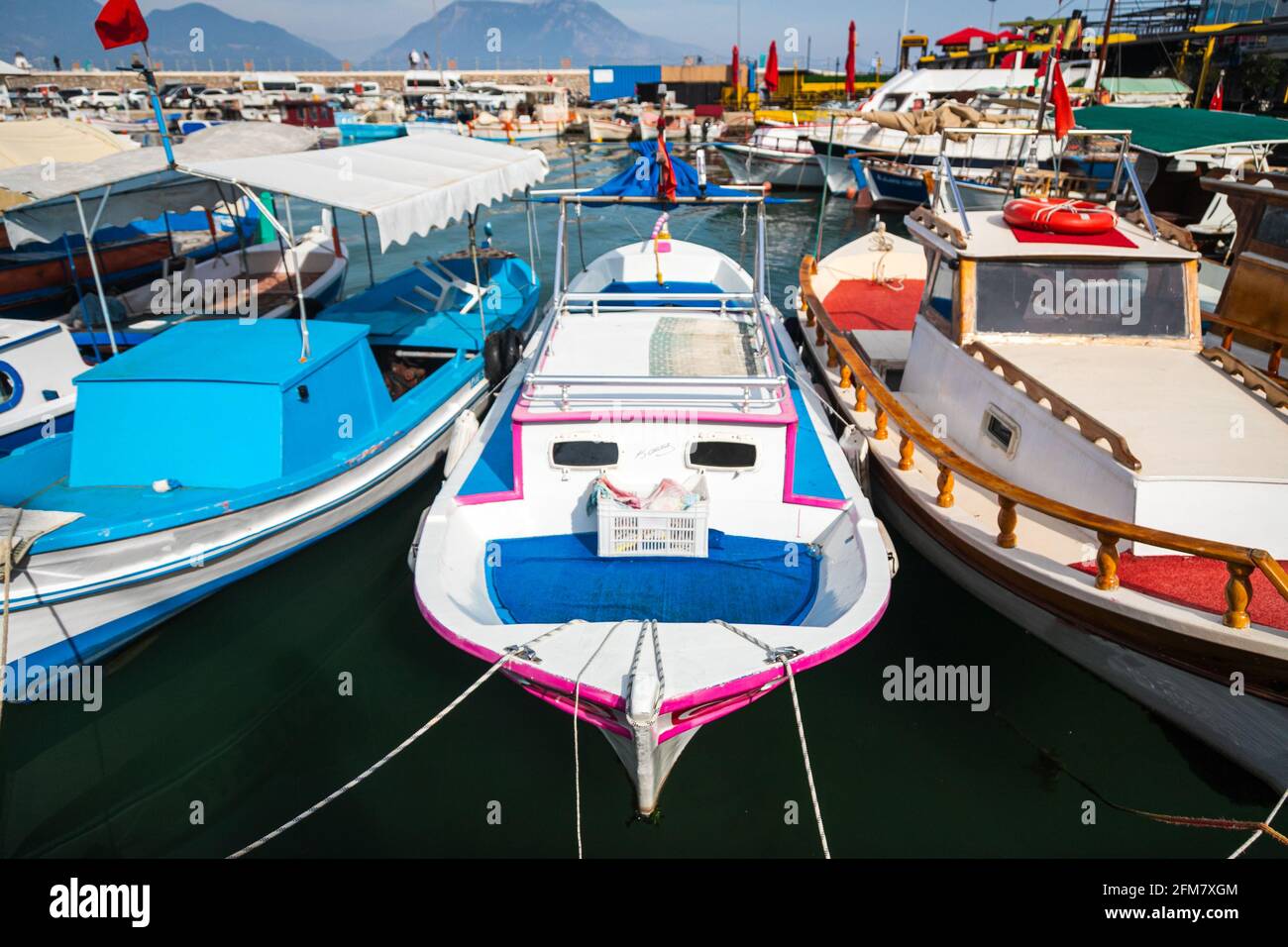 Wooden boards of boats, painted white and brown, moored to the pier
