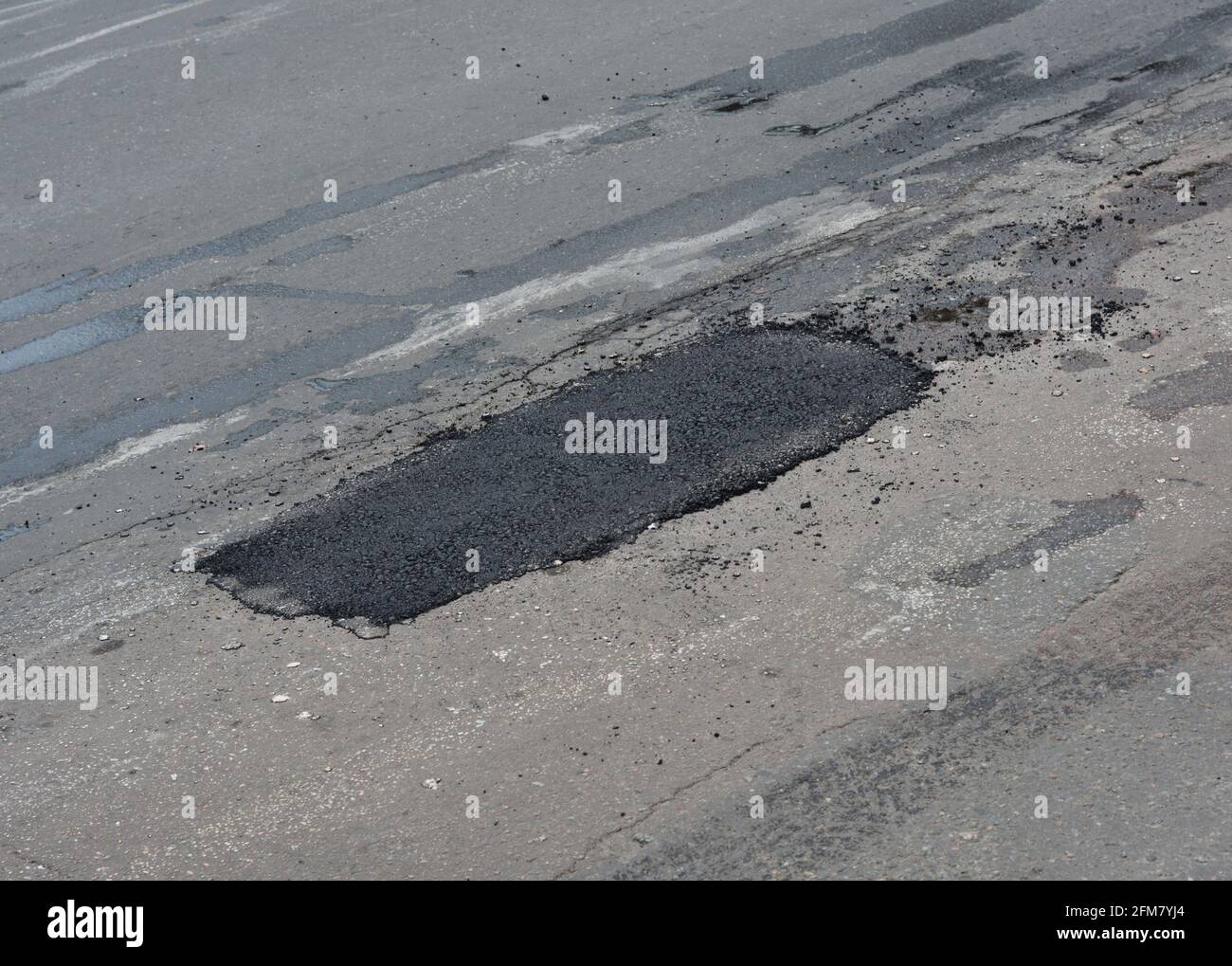 Pothole asphalt patching, asphalt road crack pothole repair, driveway, pavement patching repair. Stock Photo