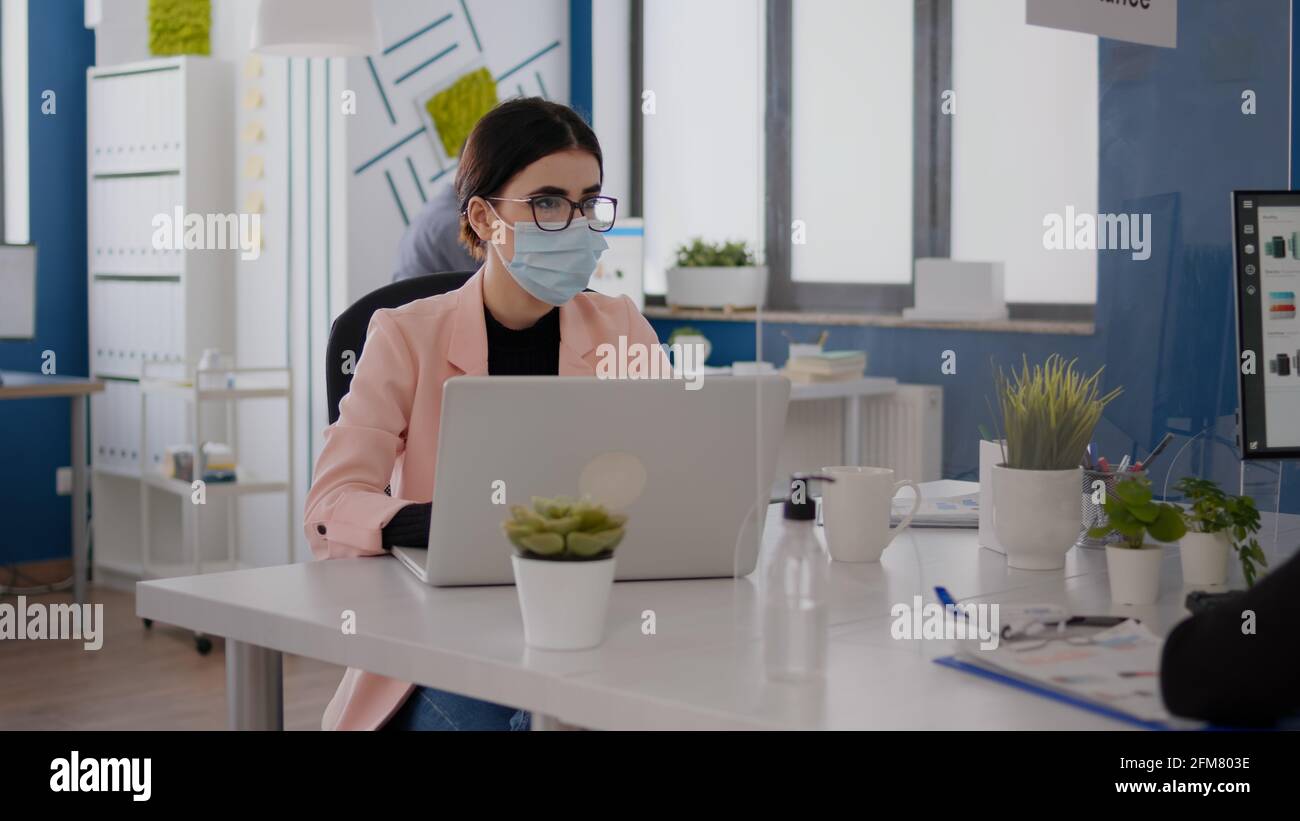 Business people with medical face masks working together in new normal ...