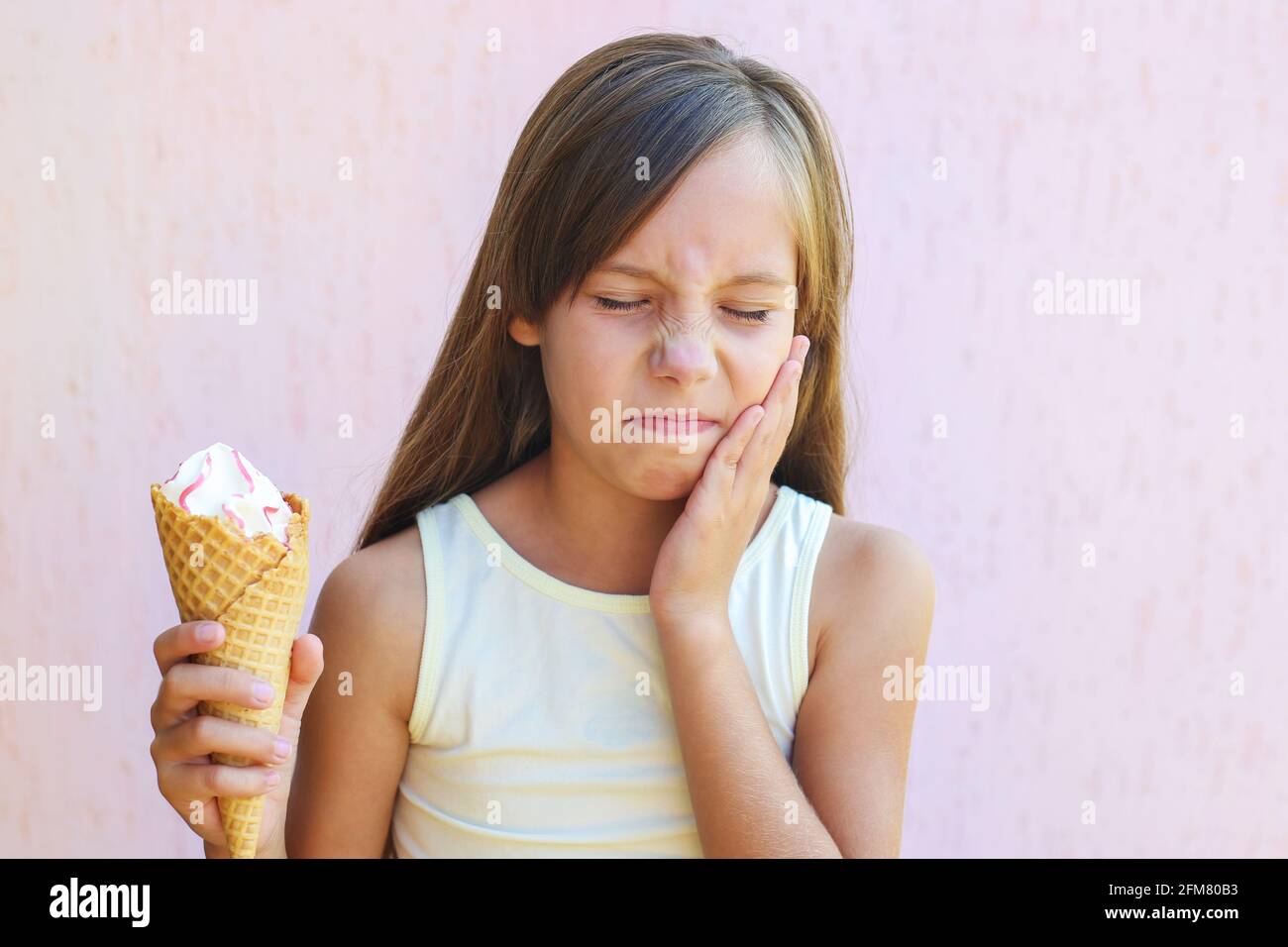 Girl has a toothache from cold ice cream Stock Photo Alamy