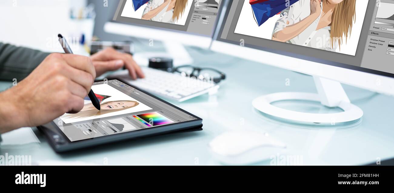 Designer And Photographer Using Multiple Computer Screens Stock Photo