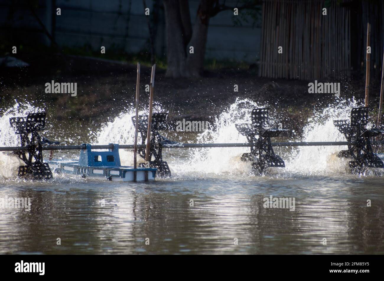 A water turbine used to rotate the water in the aquaculture pond with a ...