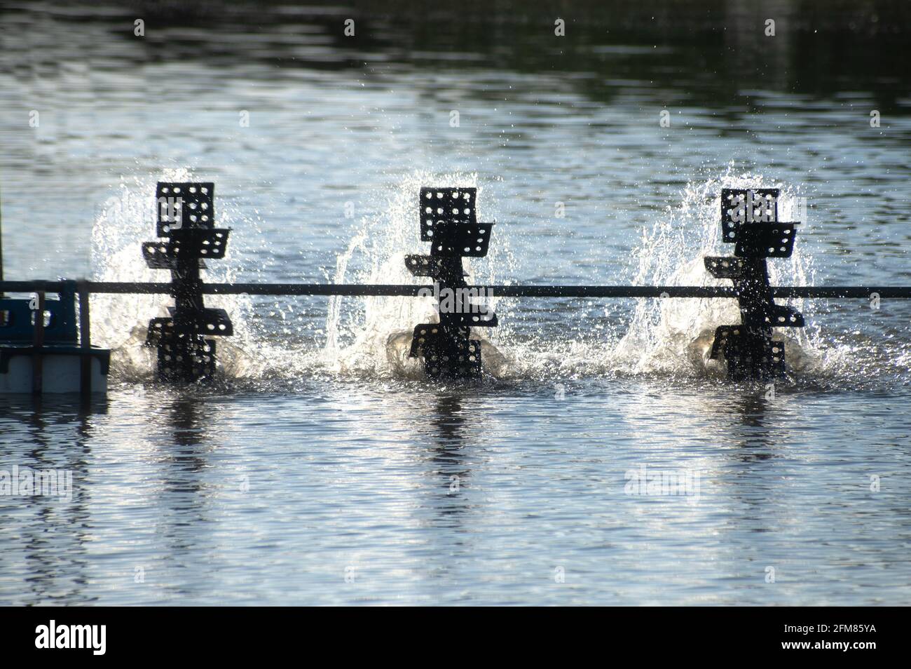A water turbine used to rotate the water in the aquaculture pond with a ...
