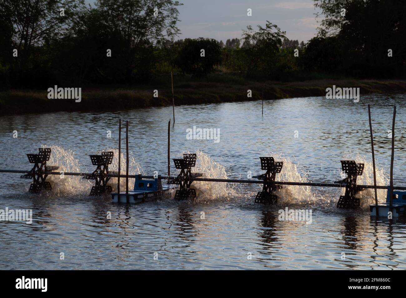 A water turbine used to rotate the water in the aquaculture pond with a ...
