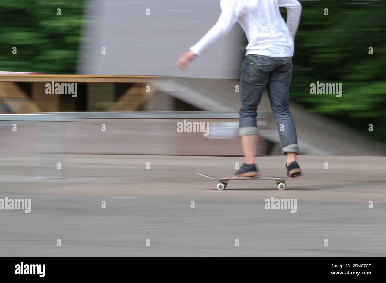 Panning detail shot of a young man on a skateboard in motion in a skatepark  Stock Photo - Alamy