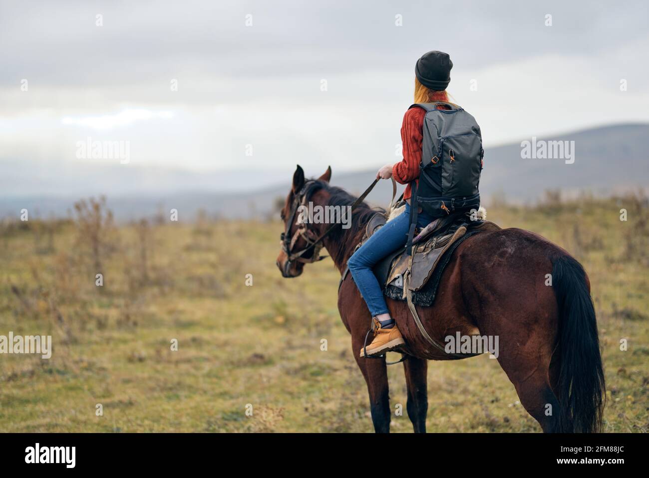 woman with backpack riding horse nature walk friendship Stock Photo - Alamy