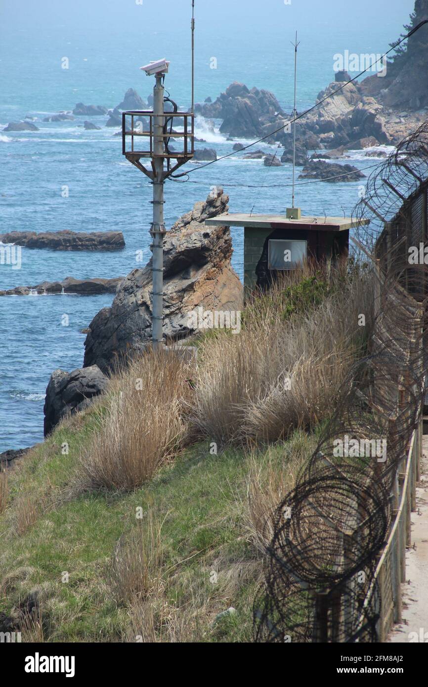 Barbed wire security fence and guard post on the eastern coast of South Korea in case of an invasion from North Korea Stock Photo