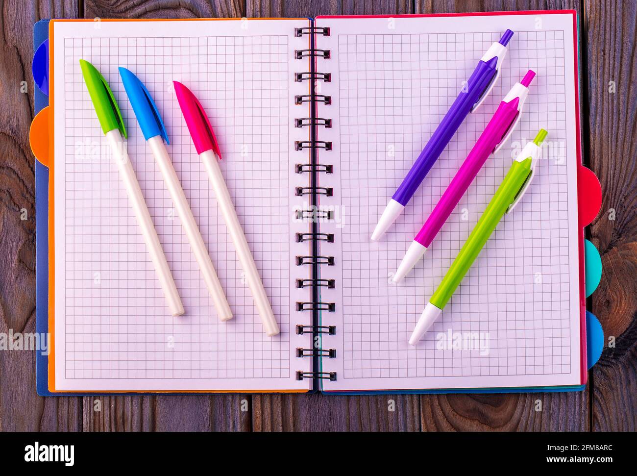 Diary (notebook) and colored pens on wooden background. Stock Photo