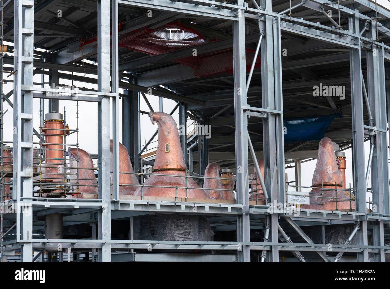 New copper distillation stills visible during construction of scotch whisky distillery for Gordon & MacPhail in Speyside at Craggan, Grantown-on-Spey Stock Photo