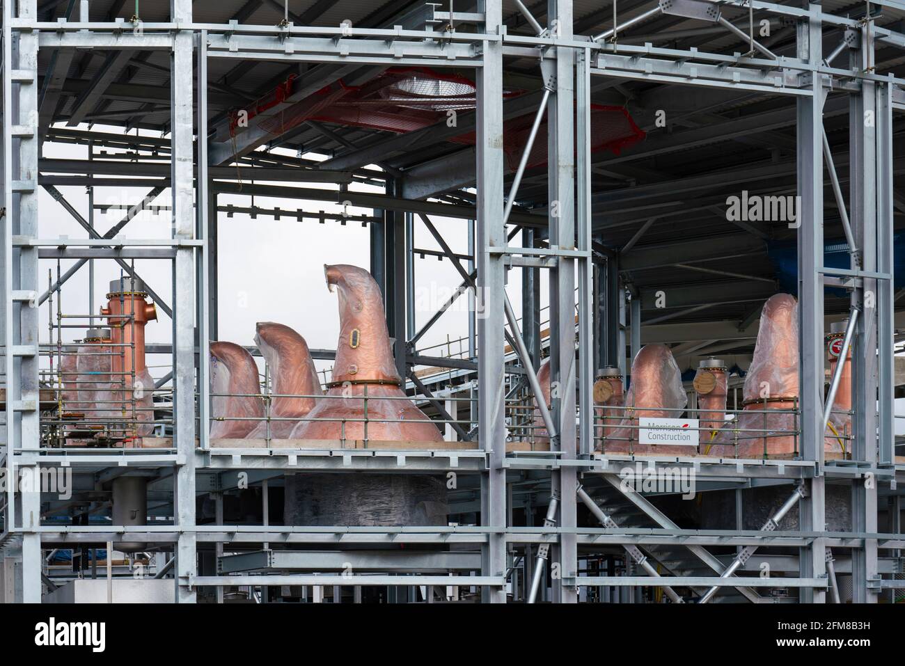 New copper distillation stills visible during construction of scotch whisky distillery for Gordon & MacPhail in Speyside at Craggan, Grantown-on-Spey Stock Photo