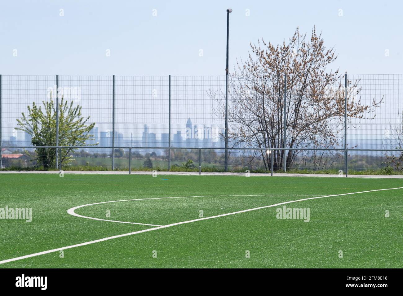 Kronberg Im Taunus, Germany. 25th Apr, 2021. The sports field of the SG Oberhöchstadt. In the background you can see the skyline of Frankfurt. Credit: Sebastian Gollnow/dpa/Alamy Live News Stock Photo