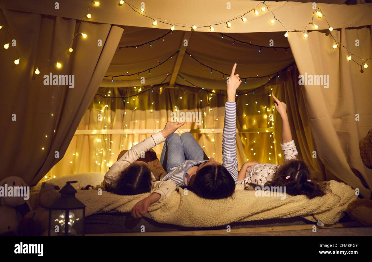 Mother with lovely daughter kids lying in cozy home tent and have nice talk Stock Photo