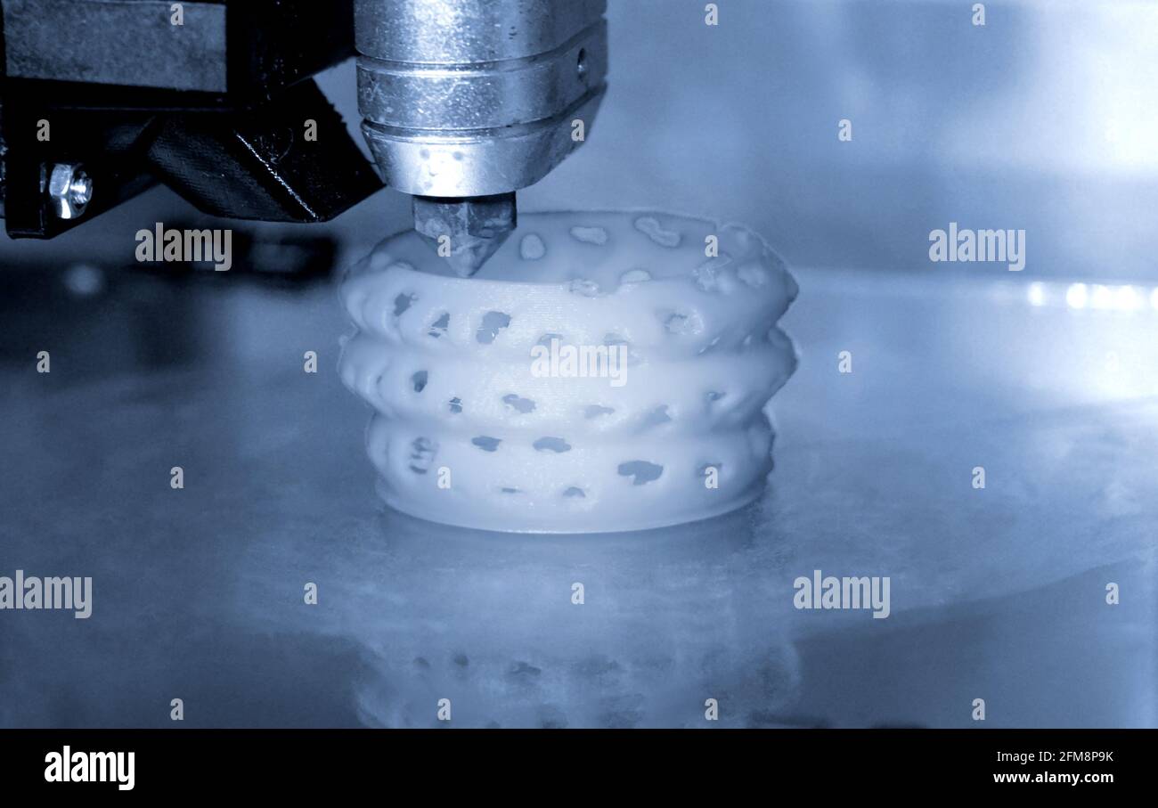 3D printer prints bkue gray form figure close Stock Photo