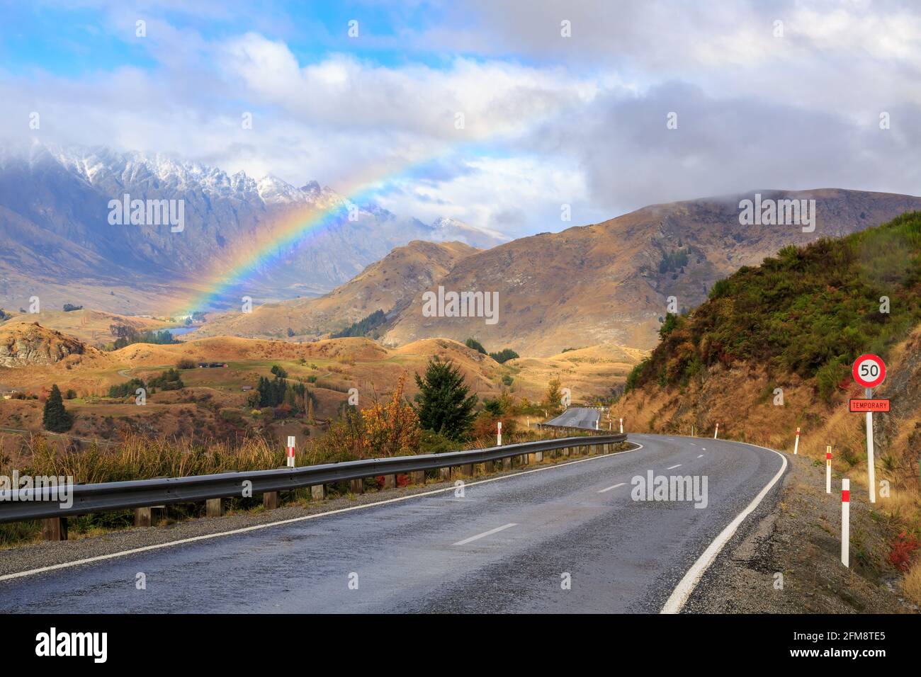 A rainbow in the valley between The Remarkables mountain range and Coronet Peak in New Zealand's South Island Stock Photo