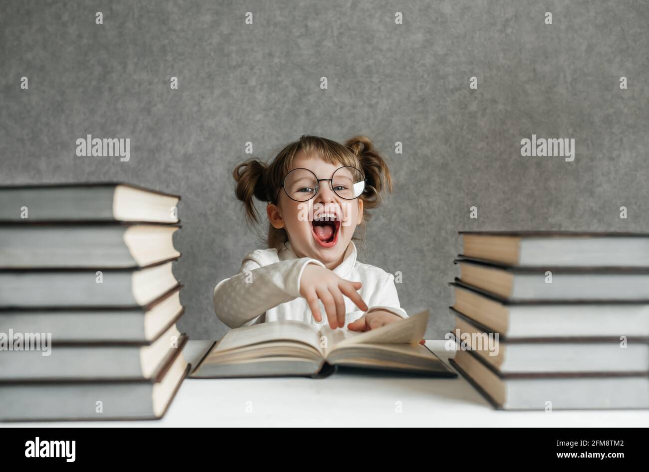 Cute kid girl preschooler with books at home Stock Photo - Alamy