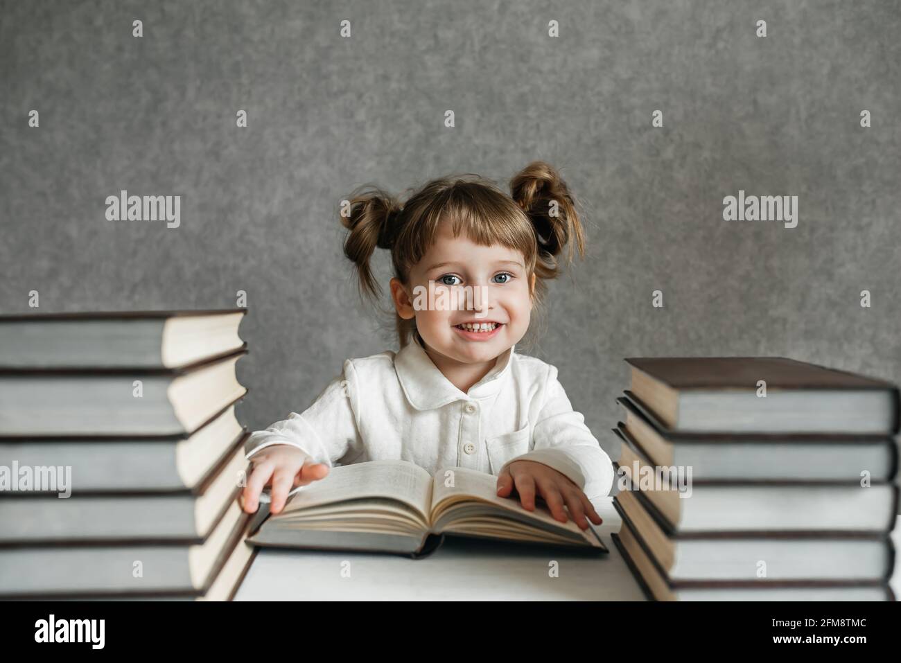 Cute kid girl preschooler with books at home Stock Photo - Alamy