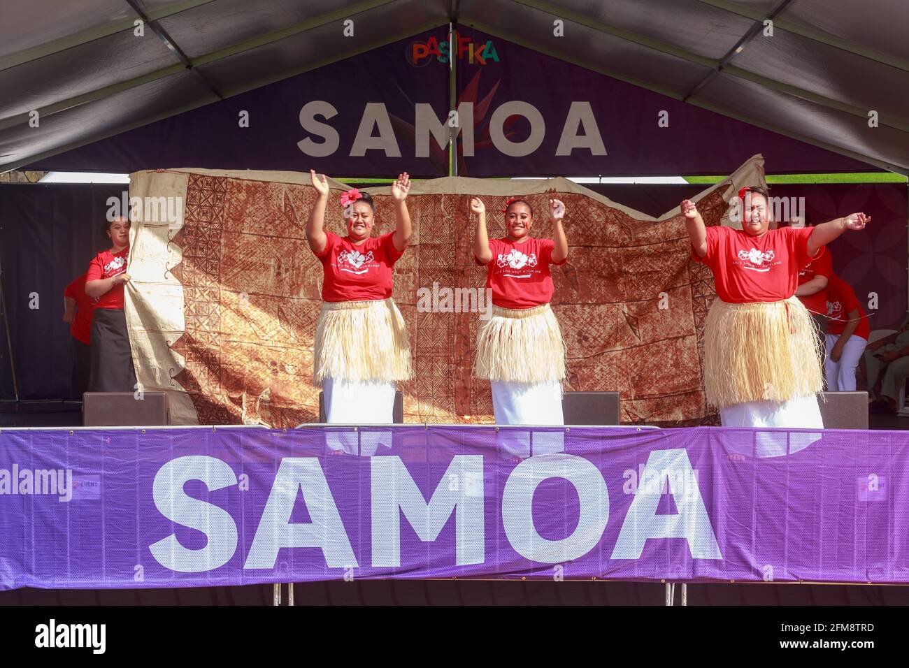 A cultural group of female Samoan dancers performing in front of a backdrop of tapa cloth at Pasifika Festival, Auckland, New Zealand Stock Photo