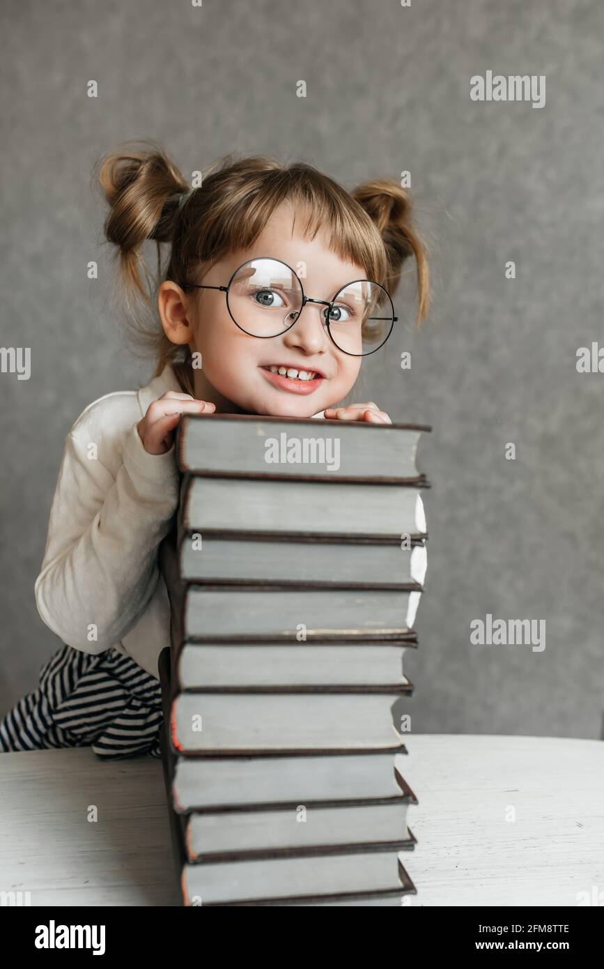 Cute kid girl preschooler with books at home Stock Photo - Alamy