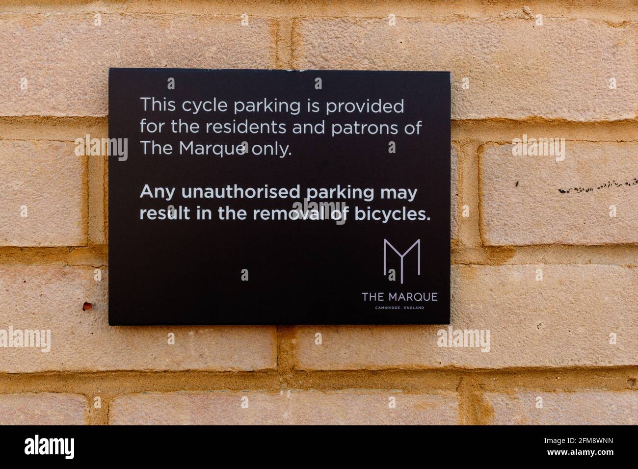 A sign on a brick wall - cycle parking at this location is for residents of The Marque (apartment block) only. Stock Photo