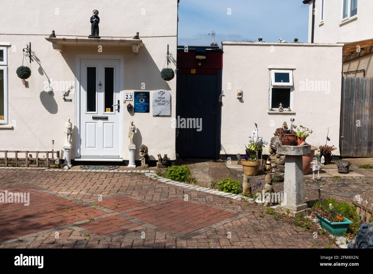 A house with a lot of garden ornaments and wall plaques.  Cambridge, UK Stock Photo