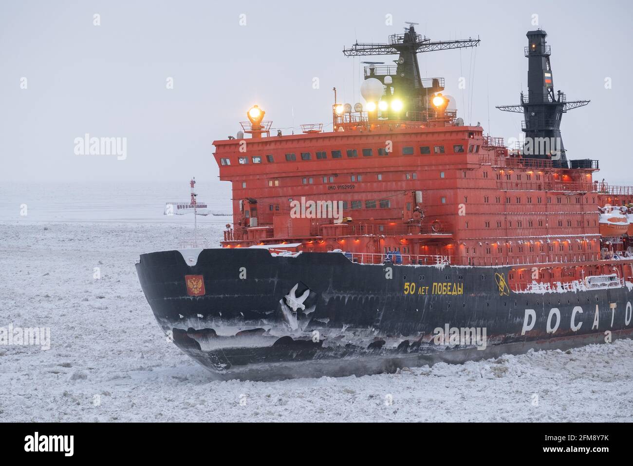 Sabetta, Tyumen region, Russia - April 4, 2021: The 50 let Pobedy icebreaker moves into ices. Overcast, light snow is falling. Stock Photo