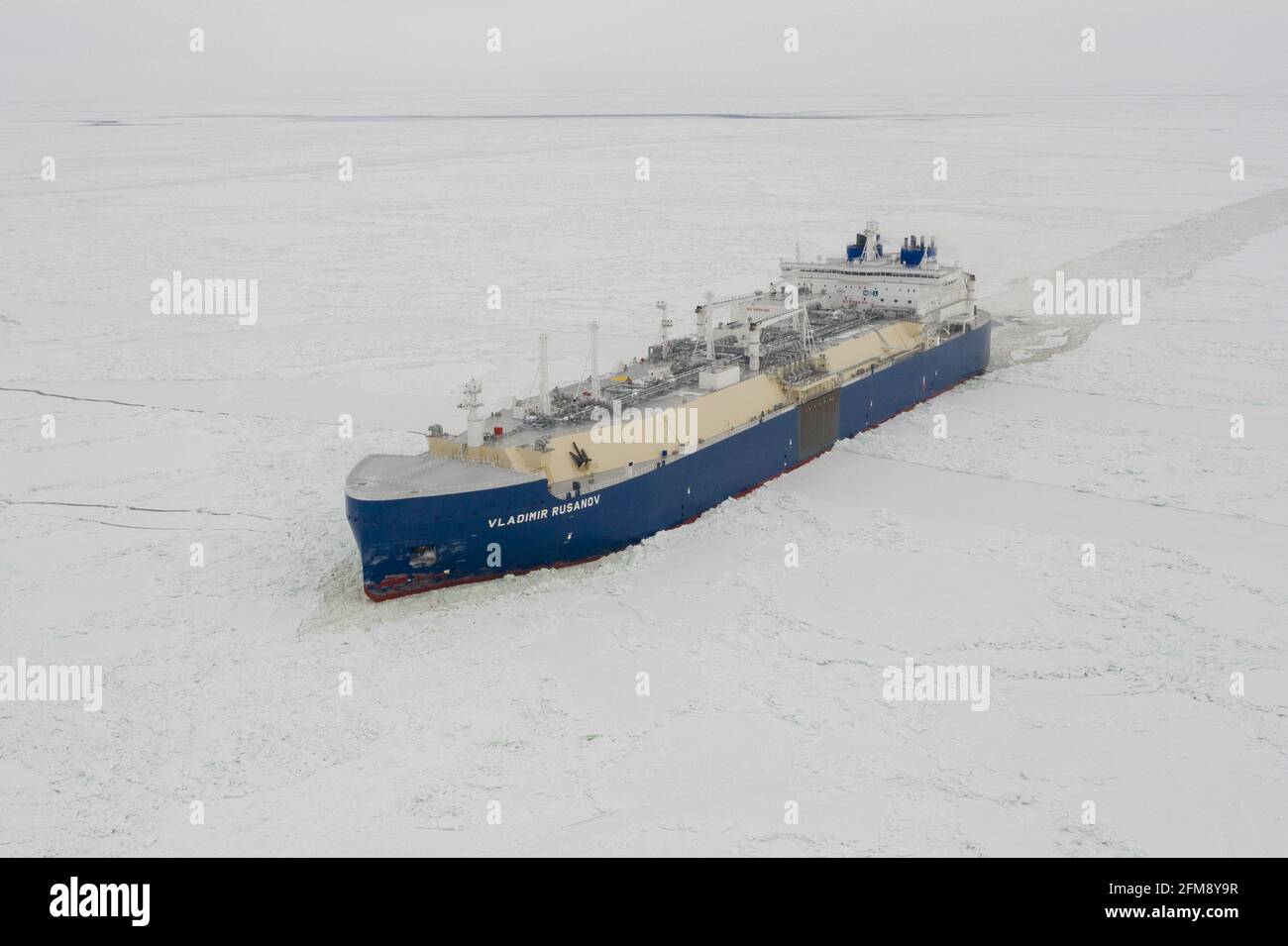 Sabetta, Yamal-Nenets Autonomous Area, Russia - April 7, 2021: VLADIMIR RUSANOV liquified petroleum gas tanker moves on ice. Overcast, light snow is f Stock Photo