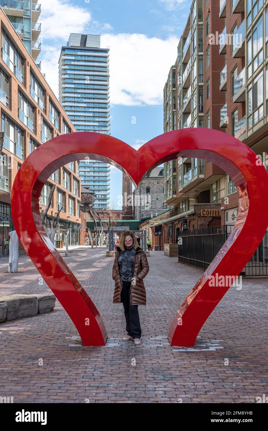 Portrait of a real middle woman of Latin American ethnicity in the Distillery District in the Old Town of Toronto, Canada. The image shows the sculptu Stock Photo