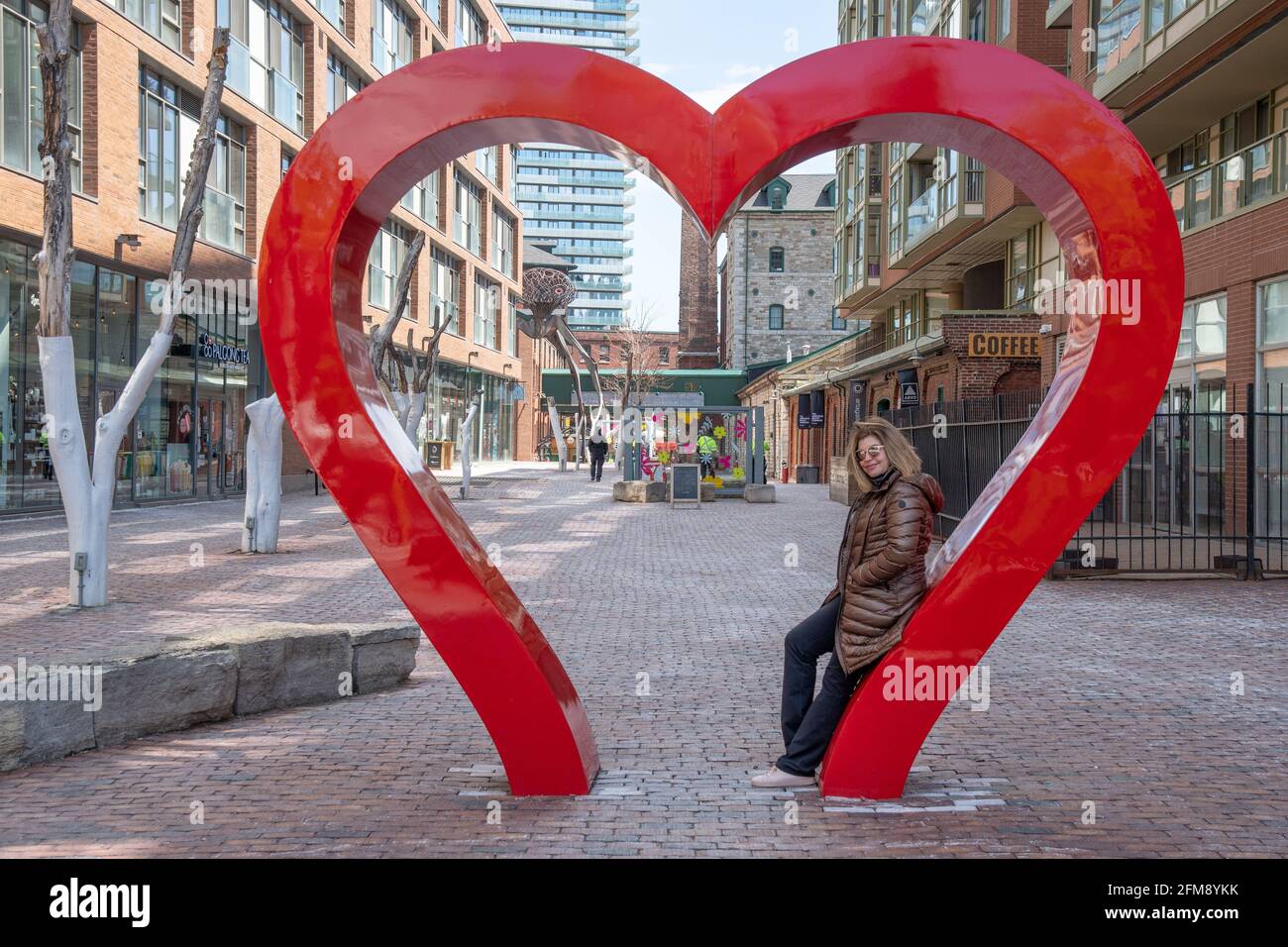 Portrait of a real middle woman of Latin American ethnicity in the Distillery District in the Old Town of Toronto, Canada. The image shows the sculptu Stock Photo