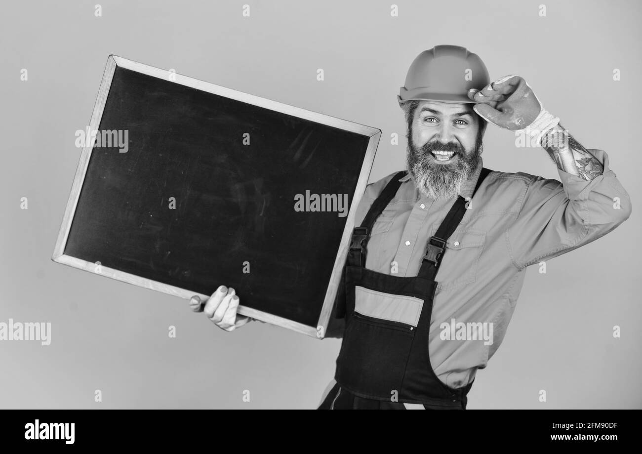 Repairman hold blackboard copy space. Handsome repairman. Price list