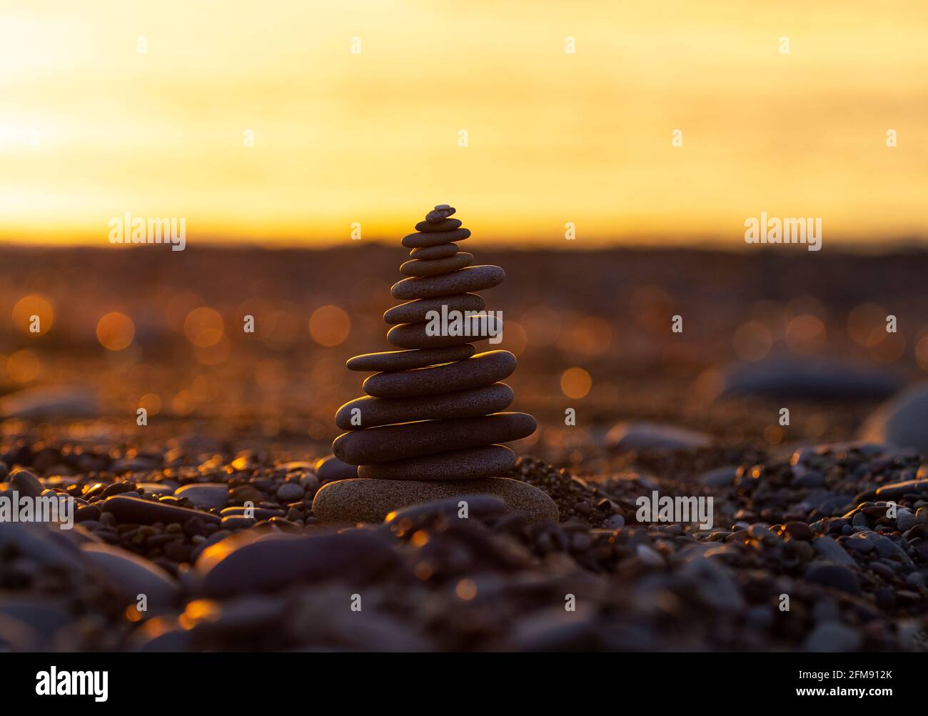 Pyramid of Stones on the Beach at Sunset, Beautiful Seascape, Seaside vacation concept, Panoramic Background, Balance Composition, Copyspace Stock Photo