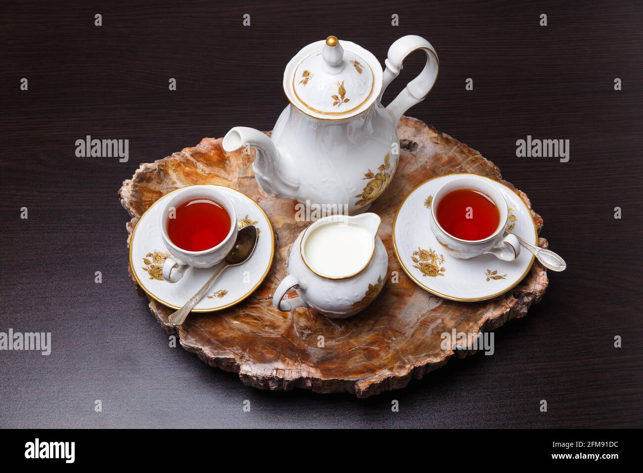 Elegant coffee set on an exclusive tray made from a cut of ancient petrified wood Stock Photo