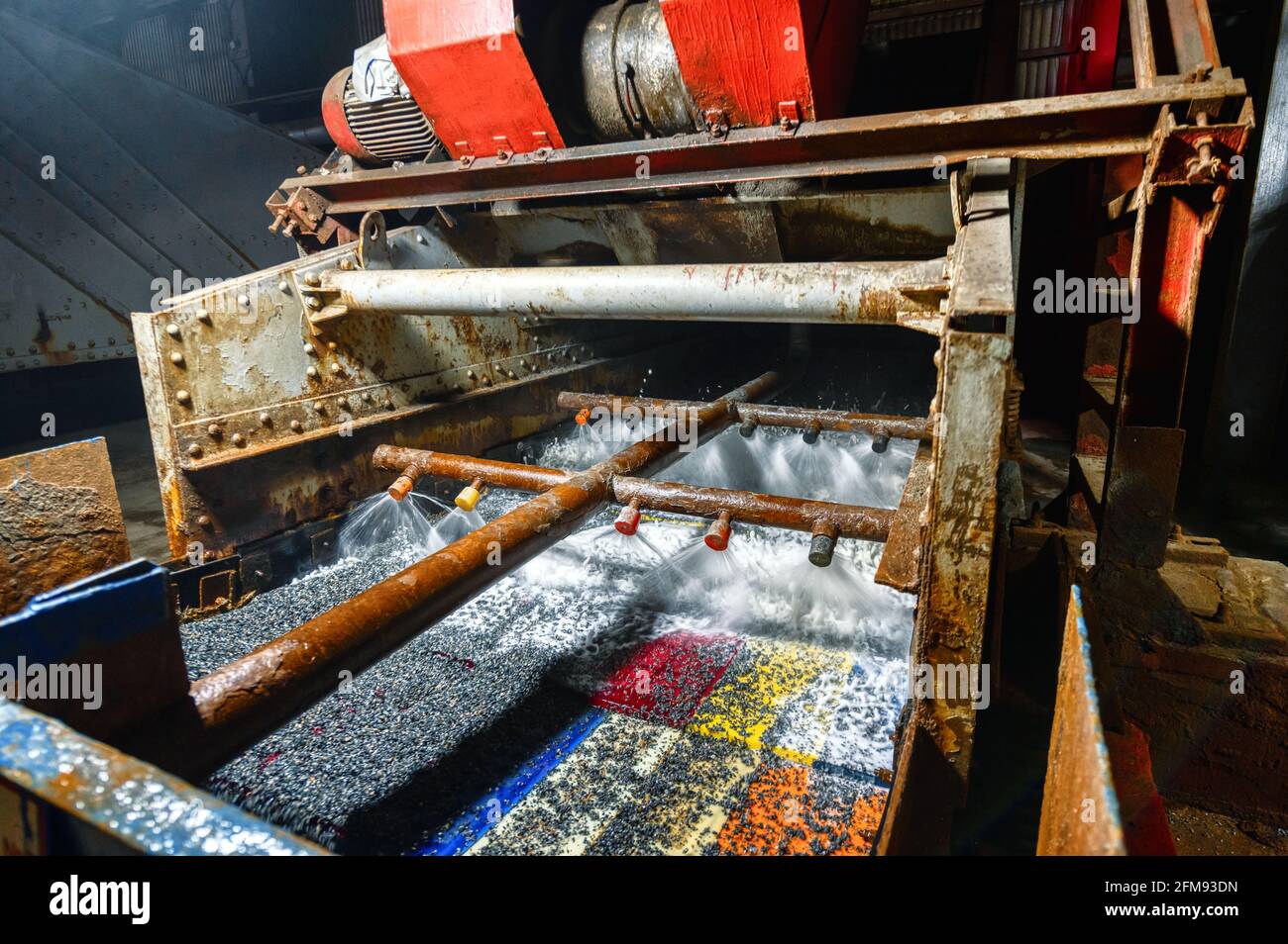 Vibrating screen, ore screening. Lots of small stones on the surface of the sieve Stock Photo