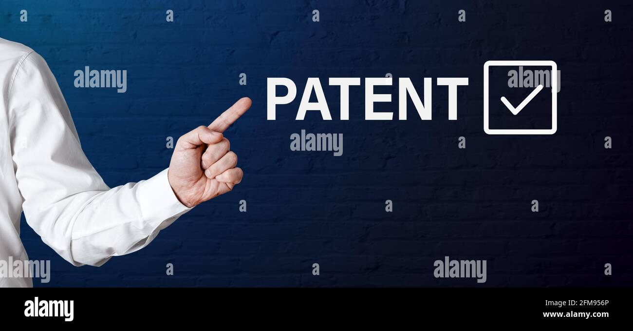 Businessman hand points to the word patent with check tick icon. Achieving property rights protection concept. Stock Photo