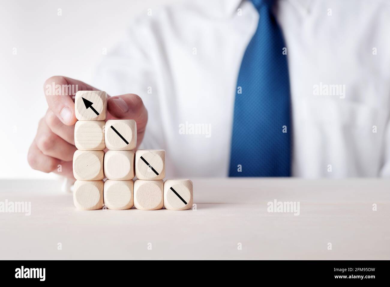Businessman placing the stack of wooden cubes with an arrow pointing ...