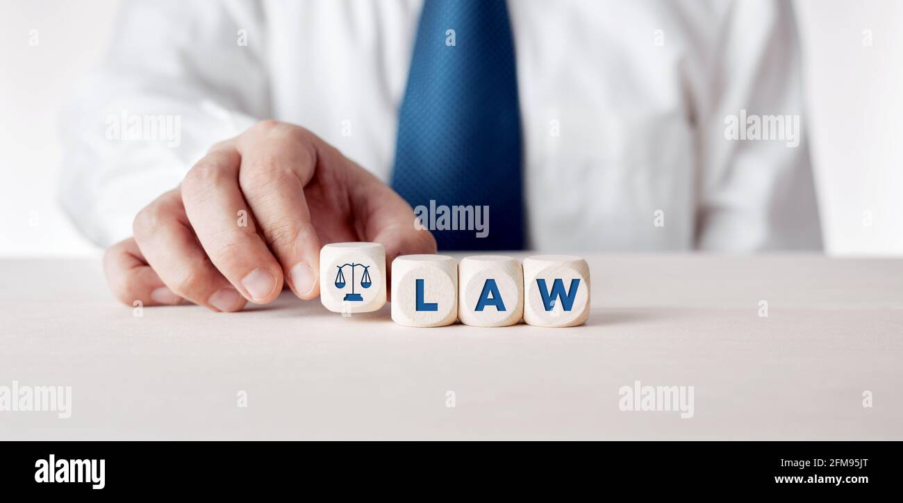 Businessman placing the wooden cubes with the word law. Business legislation or legal rules concept. Stock Photo